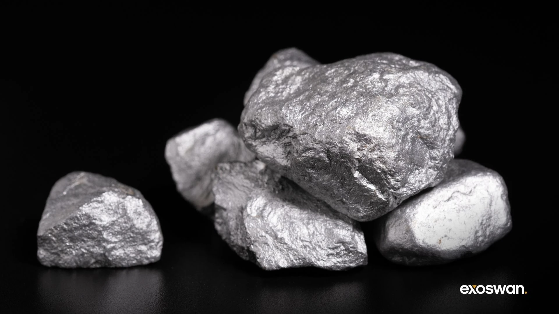 Silver-colored mineral specimens against a black background.
